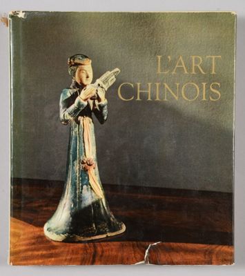 an old book with a figurine of a woman holding a knife