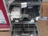 a silver dishwasher sitting on the floor next to a box