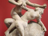 a statue of a woman on a rock with a goat