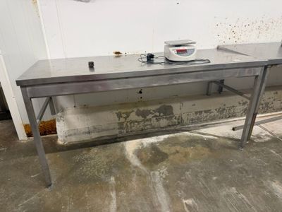 une table en métal sur laquelle se trouve une balance, dans une pièce