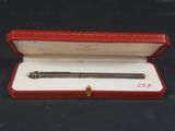 une image représentant un stylo dans un étui rouge posé sur une surface noire