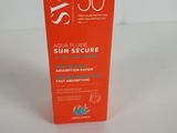 une boîte de crème solaire « Sun Secure » posée sur une surface blanche