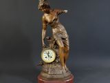 a statue of a woman with a clock on a table