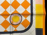 an orange and white square scarf with a yellow circle on it