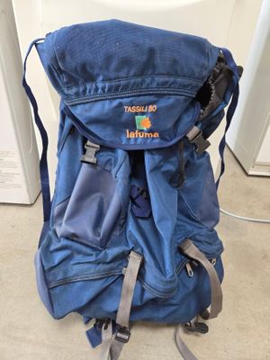 un sac à dos bleu posé par terre près d'une porte