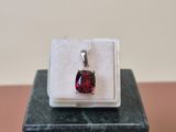 a close up of a red stone in a white box on a table