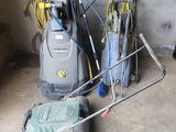 two lawn mowers sitting next to each other in a garage