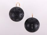 une paire de boucles d'oreilles noires et dorées sur fond blanc