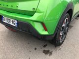 a green car that is parked on the side of the road