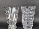 pair of clear glass vases sitting on top of a black table