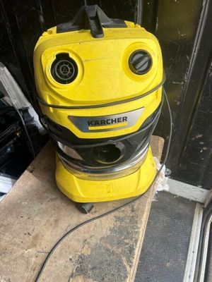 un aspirateur jaune et noir posé sur un parquet