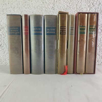 plusieurs vieux livres sont alignés sur une surface blanche
