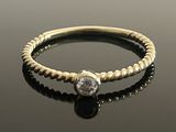 an image of a gold ring with a black and white diamond