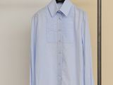 a blue shirt hanging on a clothes rack in a room
