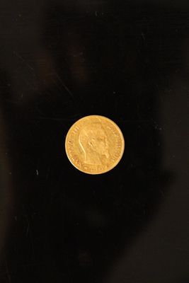 a close up of a gold coin on a black surface