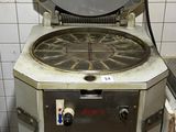 une cuisinière sur laquelle est posée une marmite dans une cuisine