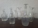several glass vases and a glass bottle on a table