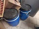 two blue drums sitting next to each other on a tiled floor