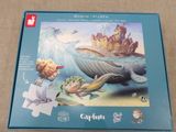 jigsaw puzzle box with a picture of a boy and a whale in the ocean