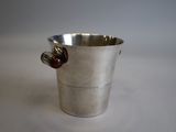 a silver cup with a red handle on a white table