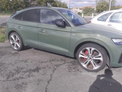 une voiture verte garée sur un parking