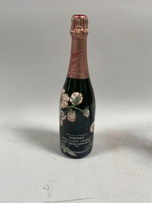 une bouteille de champagne posée à côté d'un verre de vin