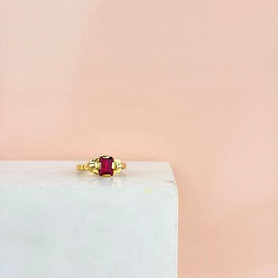 an image of a gold ring with a ruby stone on top of it