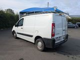 a white van parked in a parking lot with a blue roof