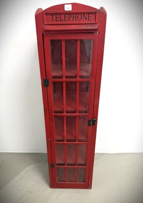 a red telephone booth with a glass door on the floor