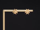 a pair of gold star earrings with diamonds on a black background