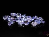 a bunch of purple sapphires on a black surface