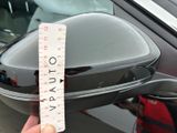 a person holding a measuring tape in front of a car