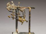 une sculpture en bronze représentant un homme assis sur une table