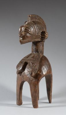 an image of a wooden statue of a woman with a bird on her back