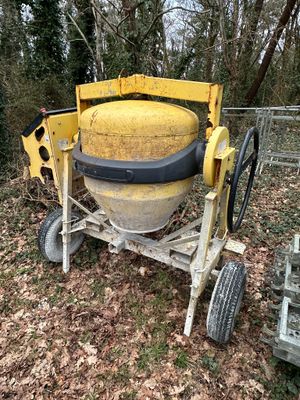a cement mixer sitting in the middle of a field
