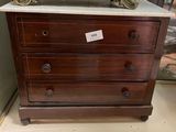 une commode en bois avec un plateau en marbre