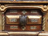 a close up of a wooden chest of drawers with a bird on it