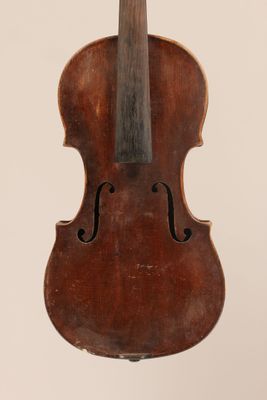 un vieux violon posé sur une surface blanche