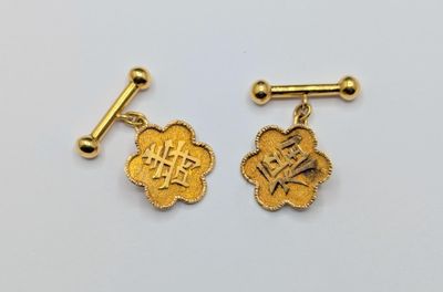 une paire de boutons de manchette en or ornés de caractères chinois