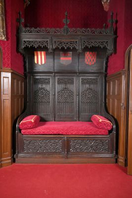 un lit en bois avec un coussin rouge dans une chambre