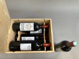 bottles of wine are in a wooden box on a table