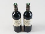 two bottles of wine sitting next to each other on a table
