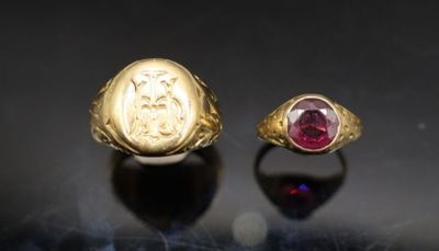 paire de bagues en or ornées de grenats sur fond noir