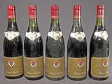 quatre bouteilles de vin sont alignées sur une table