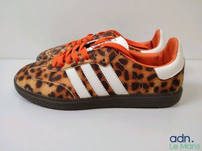 un gros plan sur une paire de chaussures à imprimé léopard posées sur une surface blanche