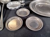 a table with a lot of silver plates and spoons on it