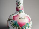 un vase blanc orné de fleurs roses, posé sur une surface grise