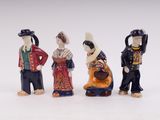 three figurines of people dressed in traditional clothing and hats