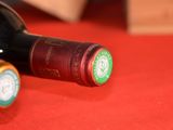 two bottles of wine sitting on a red table