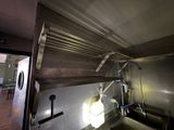 une cuisine équipée d'un évier en inox et d'une grande fenêtre